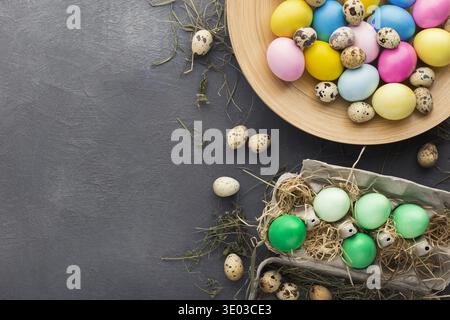 Colored Easter and quail eggs set on black table Stock Photo