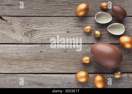 Chocolate and golden easter eggs on wooden background Stock Photo