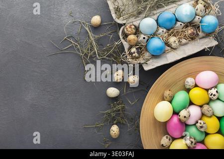 Colored Easter and quail eggs set on black table Stock Photo