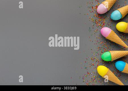 Colorful easter eggs in waffle cones on gray background Stock Photo