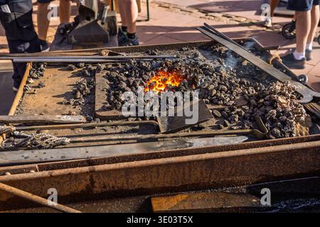 Glowing orange charcoal embers in a blacksmith forge. Blacksmith furnace with sparks and fire at local market Stock Photo
