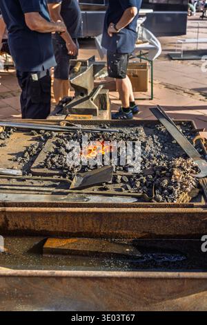 Glowing orange charcoal embers in a blacksmith forge. Blacksmith furnace with sparks and fire at local market Stock Photo