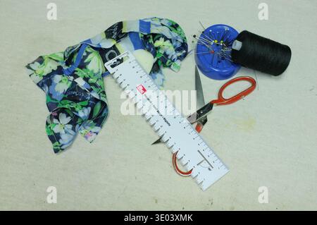 Floral Fabric, Scissors, Measuring Tape, Spool On Worktable Home Tailor Trims Fabric For Upcycle Project, Bright Daylight, Organized Tools, Casual Hob Stock Photo