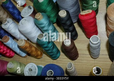 Vertical Spools On Wooden Board, Organized Rows Of Colorful Thread Pegs, Dense Stock For Sewing Or Upholstery Production, Sturdy Setup For Highvolume Stock Photo