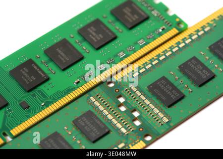 Two DDR RAM memory modules with black chips and gold contacts, closeup macro detail on white background, computer hardware upgrade and semiconductor s Stock Photo