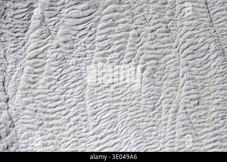 Close-up image showcasing the intricate texture and patterns of natural travertine stone, highlighting its unique, wavy formation and earthy, neutral Stock Photo