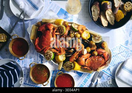 A gourmet seafood platter featuring whole crab, shrimp and assorted shellfish elegantly arranged on a rustic table. Perfect for seaside dining or a su Stock Photo
