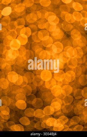 An abstract image featuring golden circles of light, reminiscent of rain droplets reflecting a sunset's glow, creating a warm and tranquil ambiance. Stock Photo