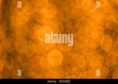 An abstract image featuring golden circles overlapping on a blurred background. The pattern resembles raindrops reflecting a sunset, creating a warm, Stock Photo
