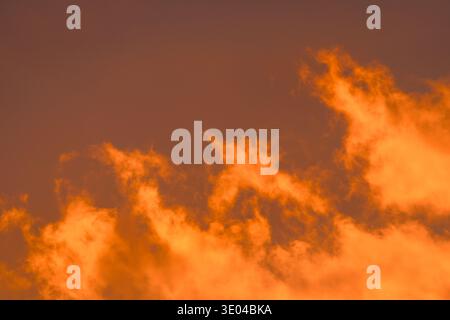 Captivating abstract image capturing golden clouds illuminated by the sunset. The vibrant colors and fluid textures create a striking visual resemblin Stock Photo