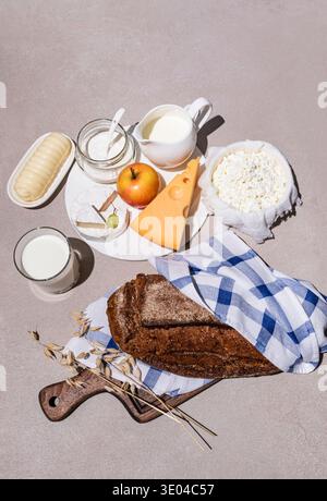 A display of traditional Shavuot foods, including assorted dairy products like cheese, milk, yogurt, with bread and an apple, symbolizing the holiday' Stock Photo
