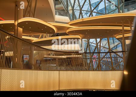 Interior view of a modern architectural space featuring organic, cloud-shaped ceiling elements with integrated warm LED lighting. The design... Stock Photo