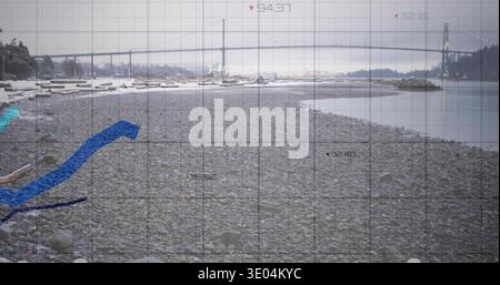 Displaying pebble beach stretching toward suspension bridge over calm bay, showing grid overlay Stock Photo