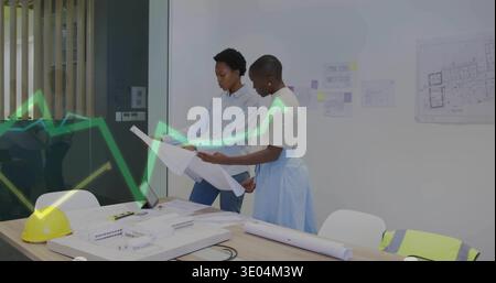 Examining two architects reviewing plans at studio, with scale model, hard hat, vest, business wear Stock Photo