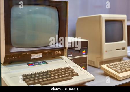 Vintage Apple computer collection displayed in Frankfurt, Germany. The foreground features an Apple II personal computer with a BASF CRT monitor,... Stock Photo