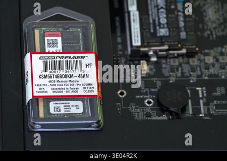 Close-up of a 48GB DDR5 ECC SODIMM memory module in protective packaging, labeled Server Premier, displayed next to a server motherboard. Stock Photo