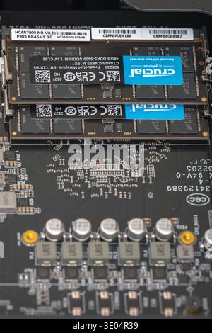 Close-up shot of 48GB DDR5 SODIMM RAM modules from Crucial installed on a Mini PC motherboard, showcasing circuitry and electronic components. Stock Photo