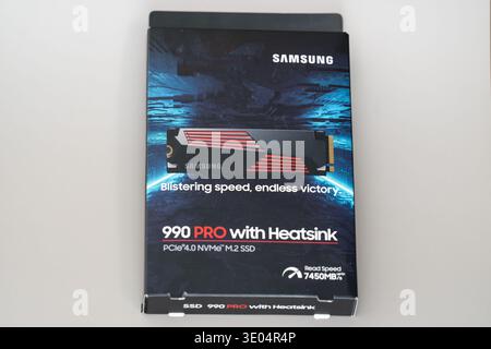 Close-up of Samsung 990 PRO PCIe 4.0 NVMe M.2 SSD box featuring heatsink, high-speed performance, and futuristic design on white background. Stock Photo
