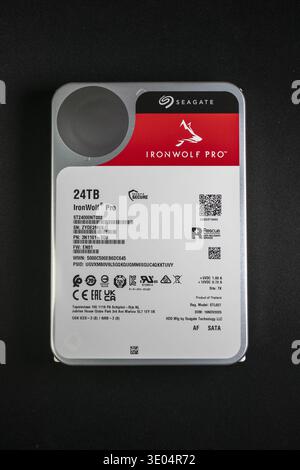 Close-up of a 24TB Seagate IronWolf Pro HDD, designed for network-attached storage, showcasing label details and specifications against black backdrop Stock Photo