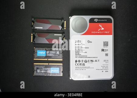 High-capacity storage devices including 24TB NAS hard drive, Samsung NVMe SSDs, Crucial DDR5 RAM modules arranged for tech and memory crisis concept. Stock Photo