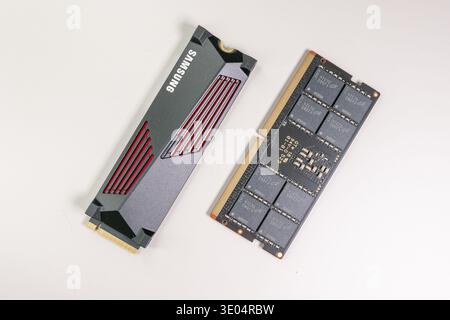 Close-up of a Samsung NVMe solid-state drive and a DDR5 memory module, showcasing computer hardware components against a clean white backdrop. Stock Photo