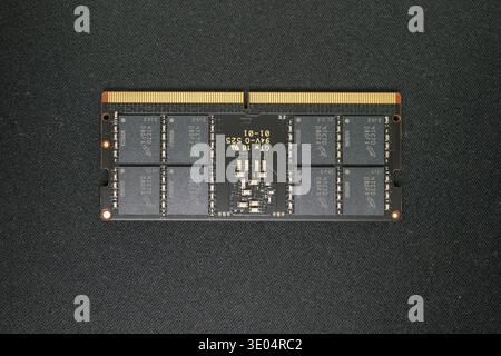 Close-up of an NVMe SSD and DDR5 RAM module showcasing computer memory technology against a dark textured surface. Stock Photo