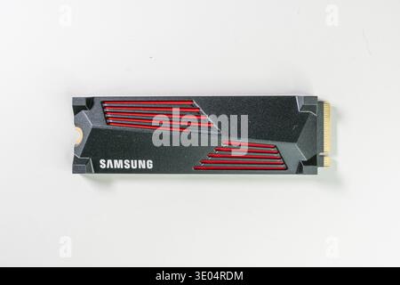 Close-up of a black and red Samsung NVMe Gen4 SSD against a clean white background, highlighting modern computer storage technology. Stock Photo