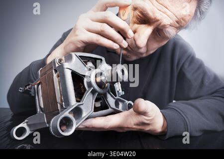 Man checking and measuring washing machine engine Stock Photo