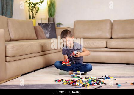 boy playing constructor sitting on the floor in the house  Stock Photo