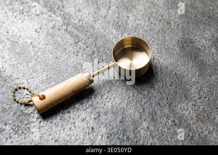 Golden scoop on gray textured table, closeup Stock Photo