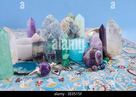 Healing crystals and pendulums arranged on patterned carpet Stock Photo