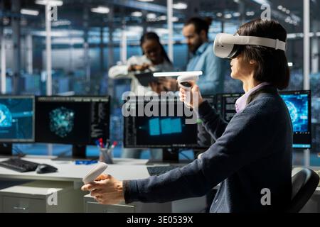 Data center developer using VR headset, adjusting AI model parameters to upgrade systems. IT professional in server room using virtual reality, scheduling deep learning checkup for hardware rigs Stock Photo