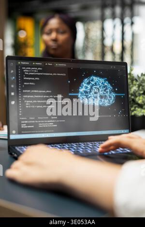 Close up of data scientist in office automating repetitive tasks using AI scripts on laptop. Startup IT worker uses deep learning tech on notebook to speed up feature implementation Stock Photo