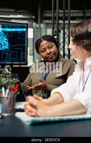 Engineering team in artificial intelligence startup office brainstorming, building scalable solutions for businesses. Teamworking colleagues doing meeting to discuss deep learning tech implementation Stock Photo