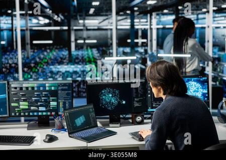 Server farm IT expert deploying machine learning tools to automate repetitive workflows. Data center system administrator managing large datasets used in AI training procedures to streamline tasks Stock Photo