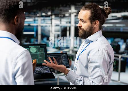 Diverse coworkers using AI tools to ensure server farm security, doing machine learning automatization for data center infrastructure. Collaborating for software management with neural network. Stock Photo