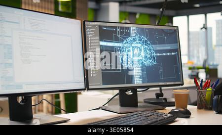 Advanced AI algorithms running on computer monitors in empty startup workspace deploying machine learning models. Artificial intelligence coding platform on PC screens in modern office Stock Photo