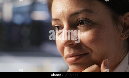 Extreme close up of smiling programmer monitoring server clusters performing AI training. Upbeat data center worker supervising high tech computing systems managing machine learning operations Stock Photo