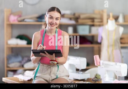 Woman dressmaker makes pattern using tablet Stock Photo