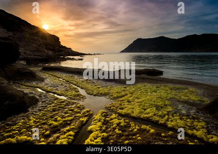 A serene coastal sunset, on a rocky coastline. Porto Ferro, Alghero, Sardinia, Italy Stock Photo