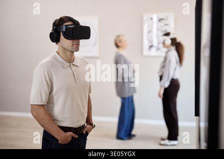 Caucasian Young Adult Man Experiencing Virtual Reality in Art Gallery Setting Stock Photo