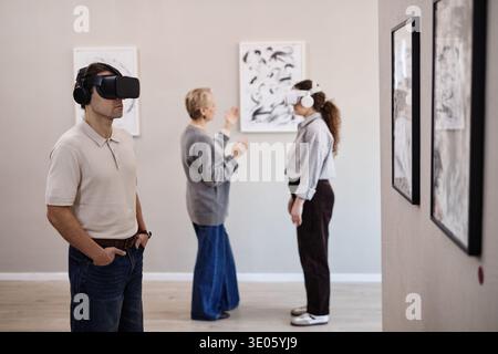 Young Man and Woman Experiencing Virtual Reality in Art Gallery Stock Photo