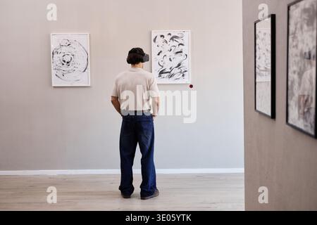 Young Adult Caucasian Man Experiencing Virtual Reality in Art Gallery Stock Photo