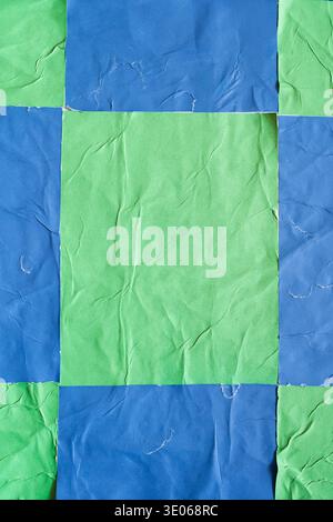 Checkered Blue and Green Vertical Posters with Wheatpaste Texture on a Wall Stock Photo