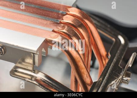 metallic cpu tower cooler base with four curved exposed copper heat pipes, integrated into silver aluminum block, closeup macro view, computer Stock Photo