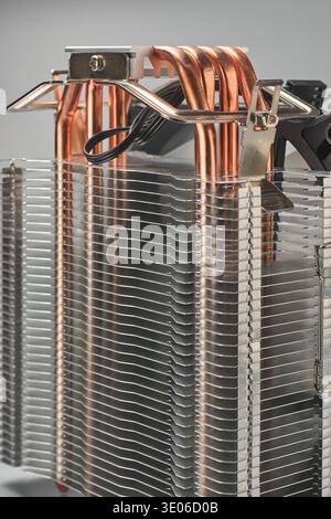 metallic cpu tower type cooler isolated gray background, stacked silver aluminum fins with exposed copper heat pipes and secured with metal mounting Stock Photo
