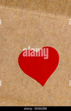 solid yellow cardboard for goods and products with red plastic hearts glued on , part of the corrugated cardboard packaging board with red hearts glue Stock Photo