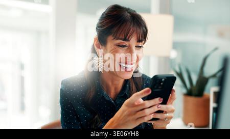 Businesswoman, typing and happy with phone, office and chat with contact on social media and message. Scroll, online and mature person with mobile for Stock Photo