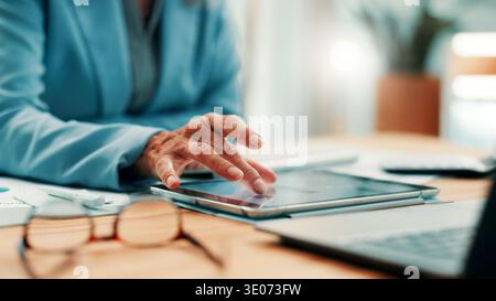 Business, tablet and hands of woman at desk for research, investment and online website for report. Corporate, mature and person on digital tech for Stock Photo