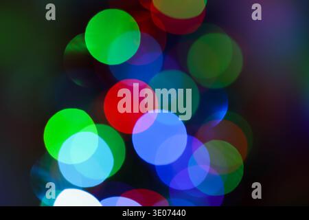 A colorful, blurry image of Christmas lights. The lights are in different colors and are scattered throughout the image. Scene is festive and joyful, Stock Photo